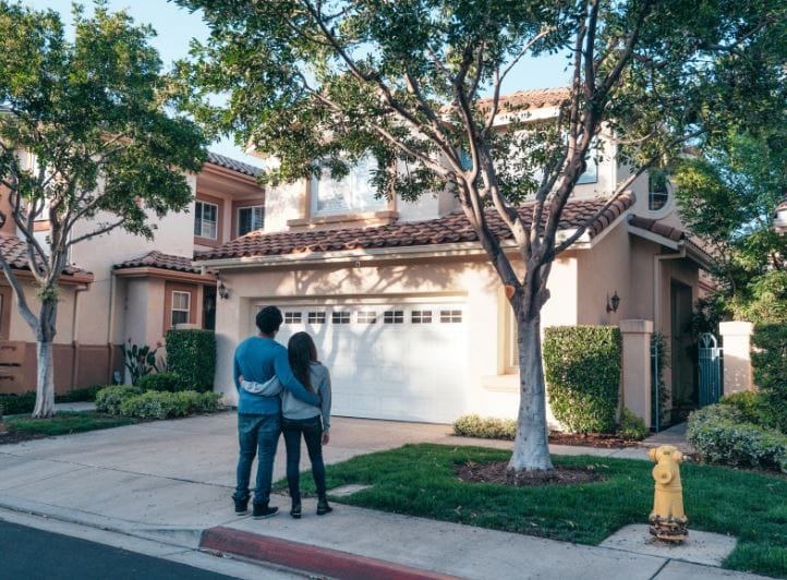 couple standing in front of home